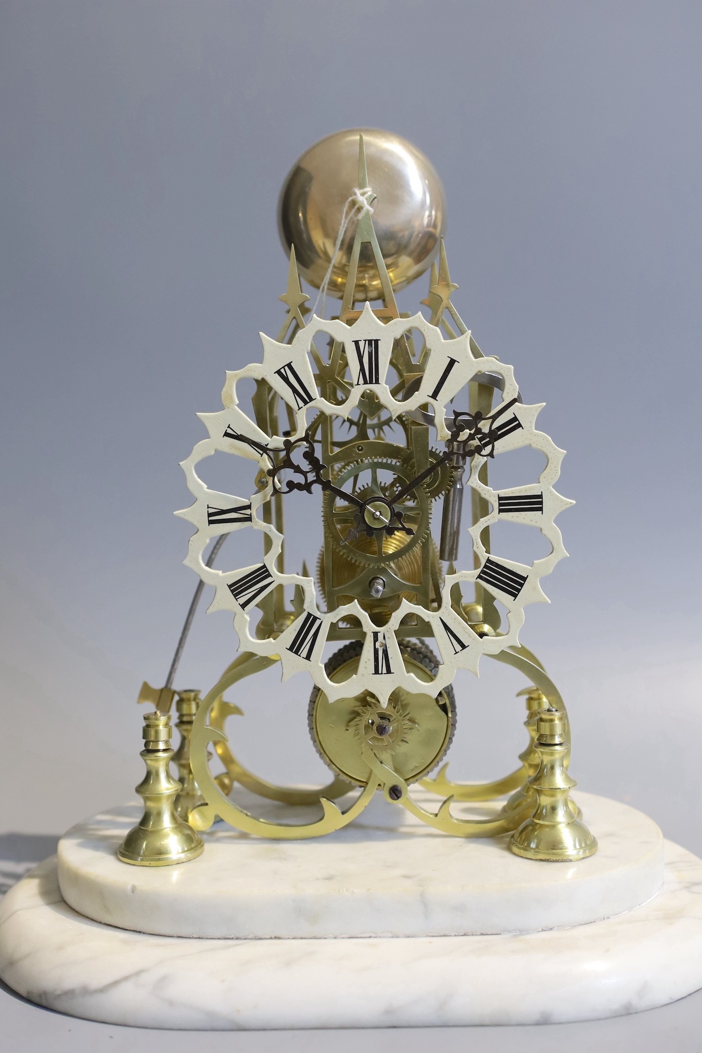 A 19th century brass skeleton mantel clock, under glass dome, with marble plinth, passing strike, the single fusee movement, with passing strike and a pierced enamelled chapter ring, height 36cm